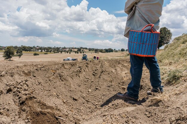 Un agricoltore irriconoscibile nel campo durante la semina del mais