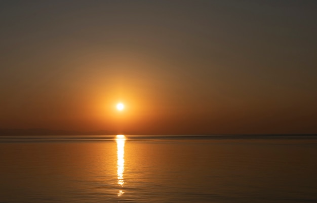 Un'alba bellissima e colorata con un percorso soleggiato sul mare.