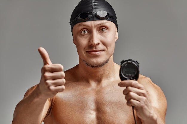Un allenatore con un cronometro nelle sue mani un allenatore di nuoto sportivo con un timer nelle sue mani sfondo grigio spazio copia