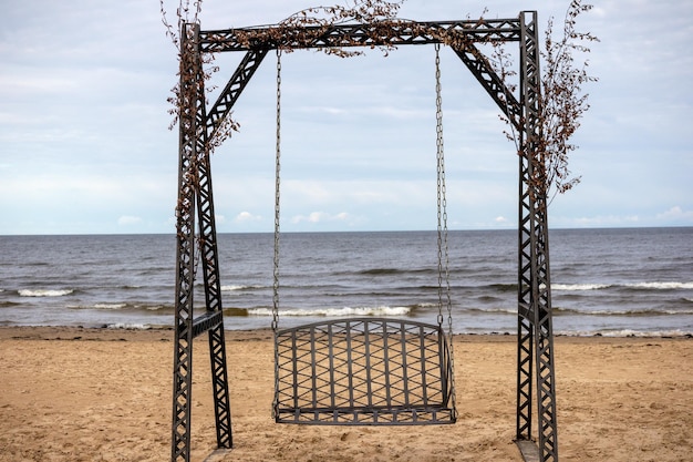 Un'altalena sulla spiaggia con l'oceano sullo sfondo.