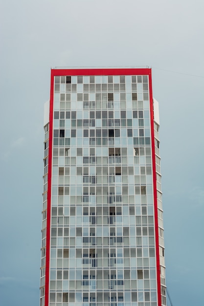 Un alto edificio multipiano con solo un cielo nuvoloso serale.