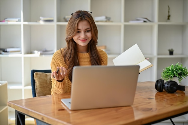 Un'amichevole tutor online freelance femminile asiatica sta spiegando e insegnando l'inglese online a casa