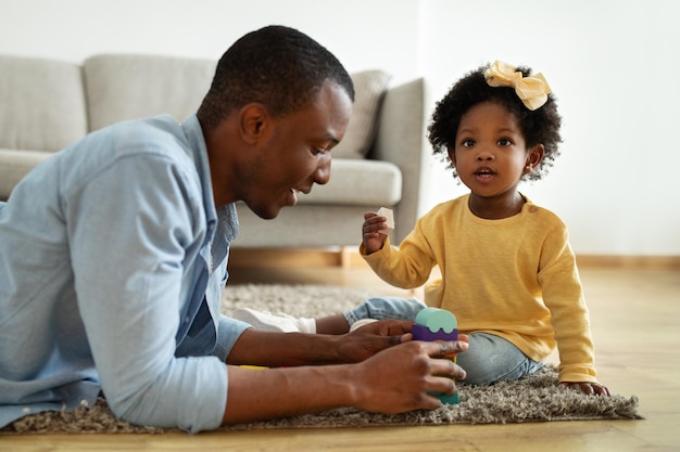 Un amorevole padre afroamericano che si diverte a giocare con sua figlia.