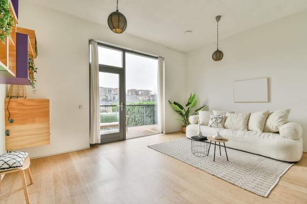 Un ampio soggiorno luminoso con un grande divano bianco sul tappeto in una casa accogliente