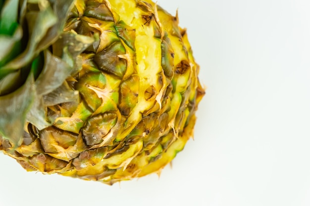 Un ananas a fette su sfondo bianco isolato, ripresa dall'alto. Vista dall'alto di ananas fresco maturo in piedi sul tavolo bianco