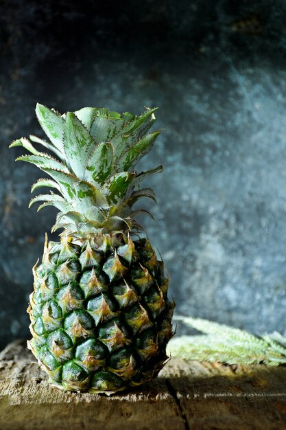 Un ananas con ombra sul vecchio tagliere in cucina al mattino