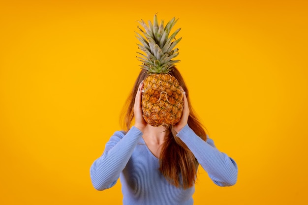 Un ananas in occhiali da sole in uno studio su sfondo giallo estate sana