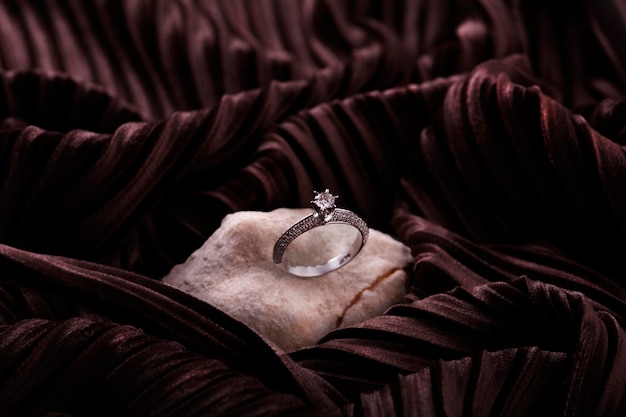 Un anello di diamanti si trova su un pezzo di tessuto.