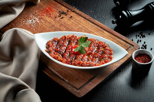 Un antipasto turco piccante ezme fatto con pomodori, peperone, prezzemolo, menta, olio d'oliva e peperoncino piccante. Una specie di adjika