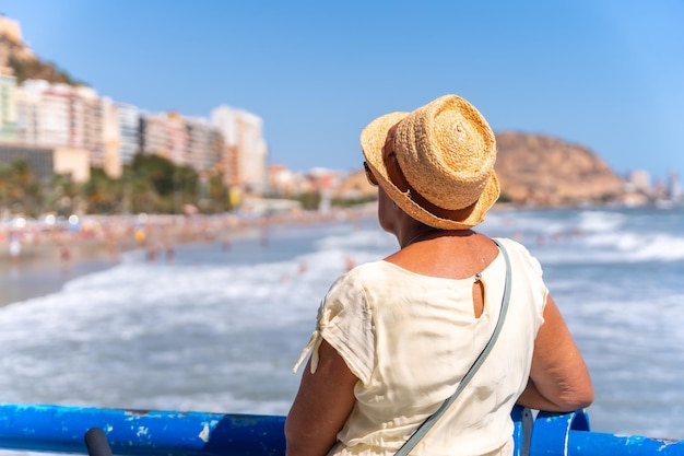 Un'anziana signora sulla spiaggia di Postiguet nella città di Alicante ha inserito viaggi vacanze per anziani