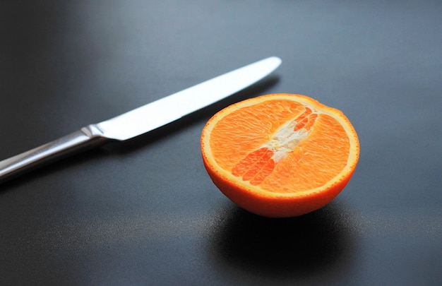 Un&#39;arancia frutta mezza pulita su un legno scuro
