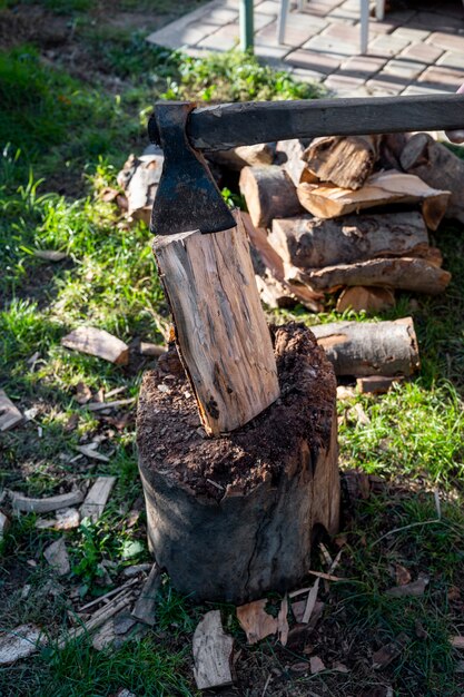 Un'ascia e un mucchio di legna tagliata all'aperto