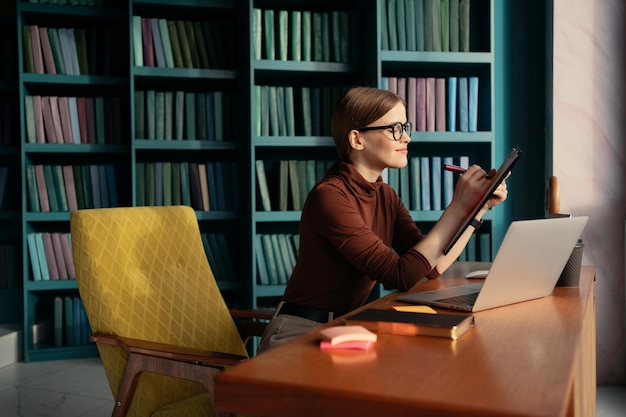 Un assistente di ufficio moderno che utilizza il progetto di avvio di lavoro online di Internet Una donna con gli occhiali