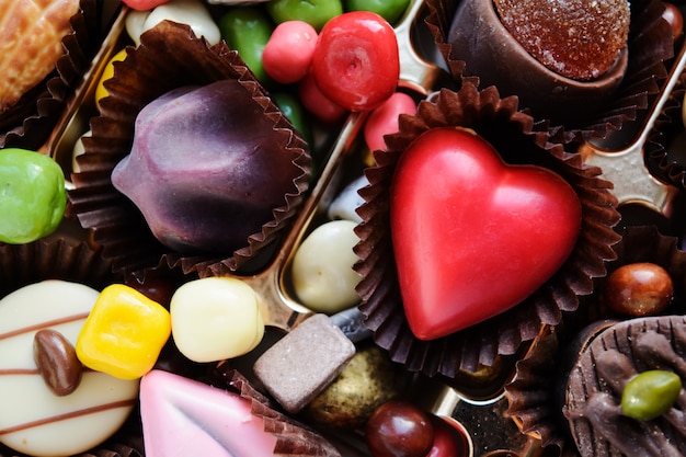 Un assortimento di dolci multicolori gourmet con il cuore. vista dall'alto.