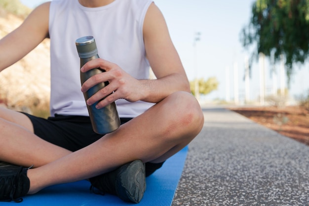 Un atleta che tiene una bottiglia d'acqua durante un allenamento idratazione nello sport copia spazio sulla destra