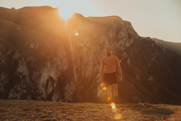 Un atleta determinato che si prepara per l'inizio dell'allenamento in cima alla montagna all'alba.