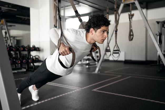 Un atleta maschio fa esercizi cardio che si allenano in palestra