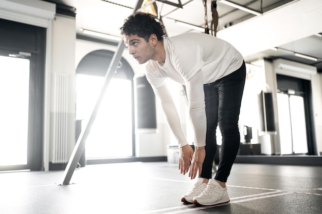 Un atleta maschio fa esercizi cardio che si allenano in palestra