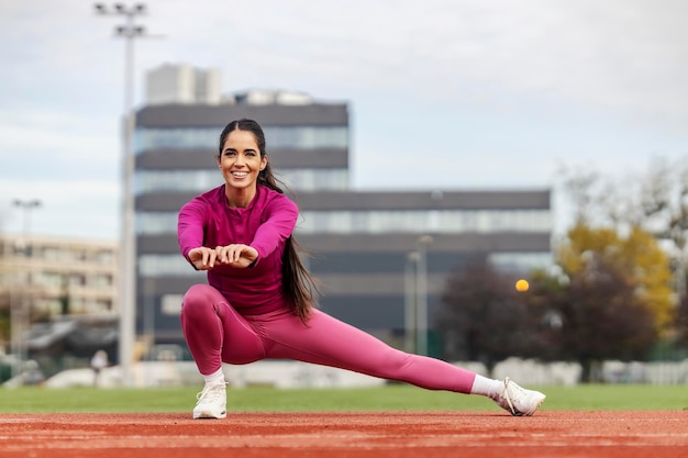 Un'atleta si allunga le gambe allo stadio