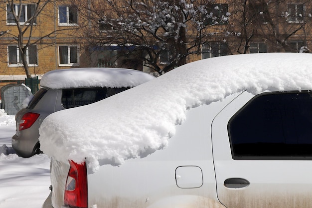 Un'auto è mostrata in un parcheggio coperto da uno strato di neve