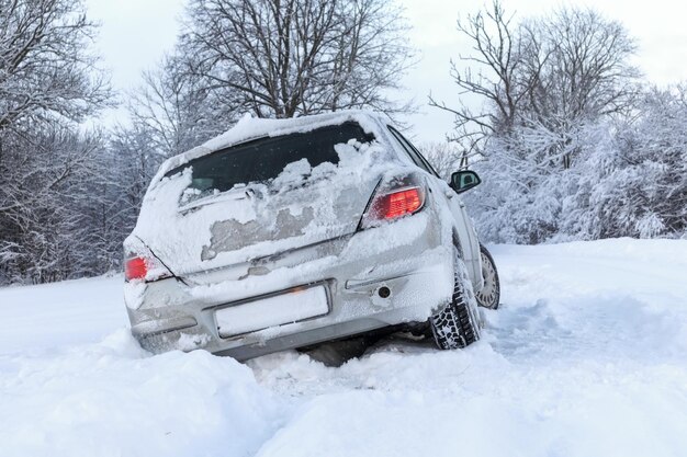 Un'auto grigia si è schiantata su una strada scivolosa e innevata in una giornata invernale.