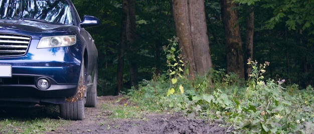 Un'auto nella foresta attraversa il fango