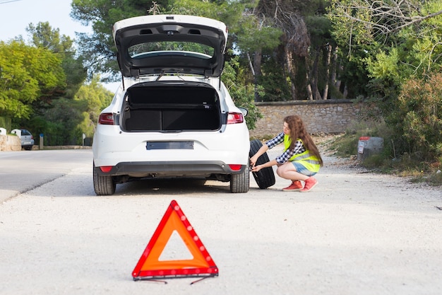 Un'auto rotta, un segno di incidente e una donna capisce qual è il problema