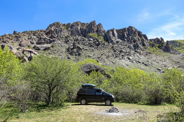 Un'auto sullo sfondo di antiche montagne calcaree in una foschia d'aria Demerji Crimea Russia maggio 2021