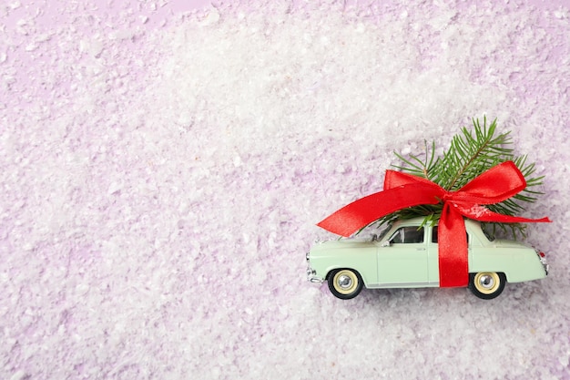 Un'auto verde con un albero di Natale e un fiocco rosso