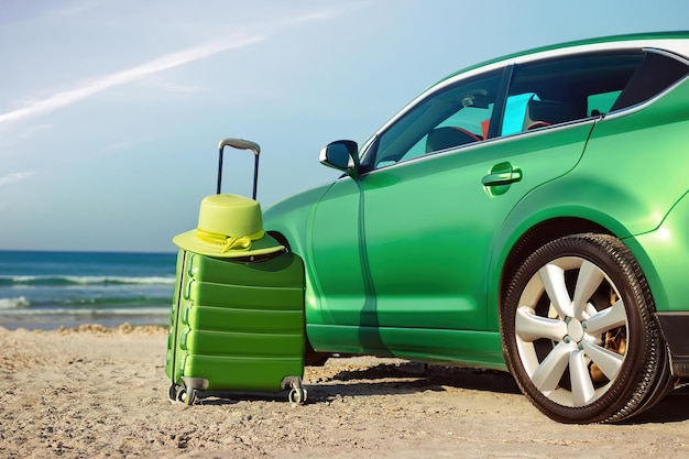 Un'auto verde sulla spiaggia Concetto di bandiera del turismo