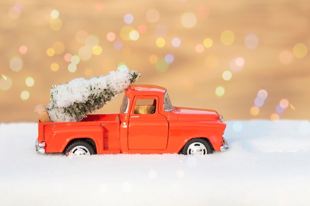 Un'automobile rossa porta un albero di Natale innevato nella parte posteriore, il concetto di Natale, capodanno,