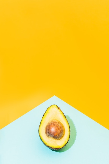 Un avocado su uno sfondo blu e giallo concetto estivo cibo messicano e sano