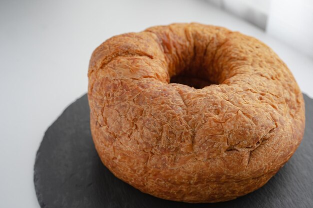 Un bagel con un buco nel mezzo si trova su una pietra nera.