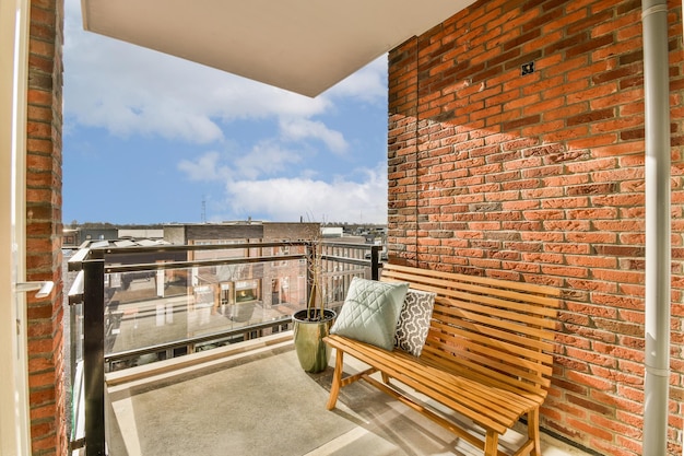 Un balcone con una panca in legno e un muro di mattoni