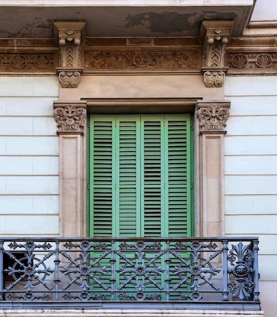 Un balcone con una persiana verde sopra