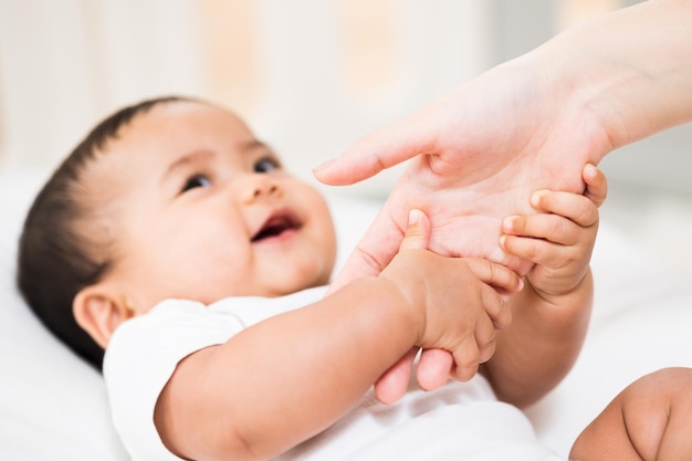 Un bambino carino che indossa un abito bianco Resta con i genitori in casa Tenendosi per mano i genitori amano la famiglia