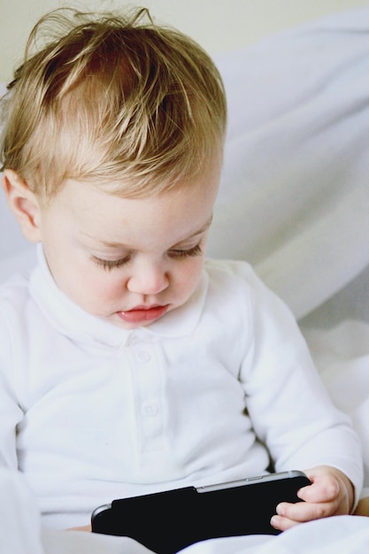 Un bambino carino con un cellulare.