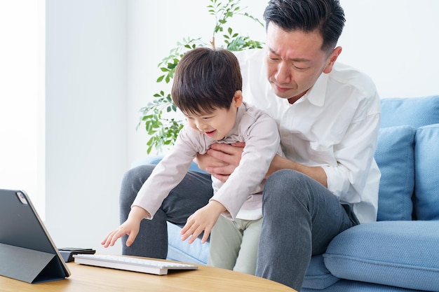 Un bambino che disturba il padre che lavora a casa