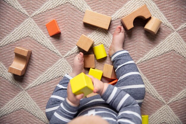 Un bambino che gioca con i blocchi di legno colorati vista dall'alto