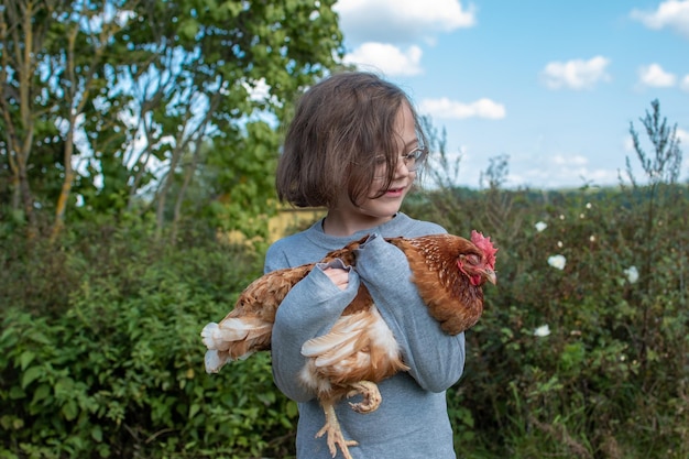 Un bambino che tiene una gallina