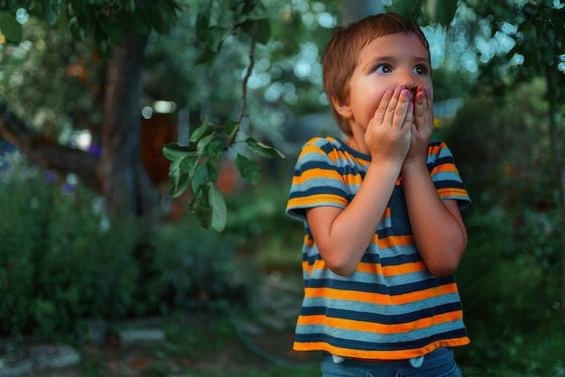 Un bambino con la faccia spaventata sta nel parco