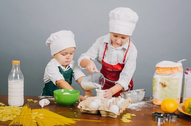 Un bambino con sua sorella sta preparando la cena