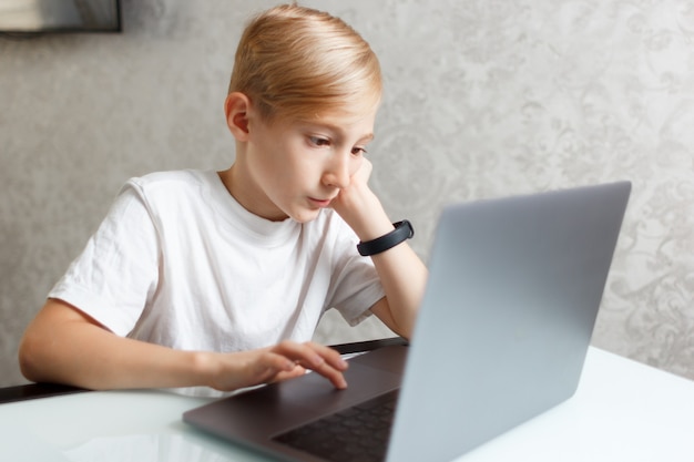 un bambino con un laptop esegue i compiti per la formazione online