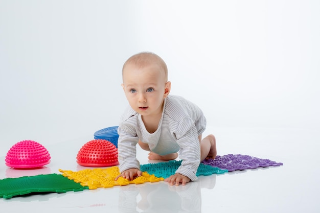 Un bambino con un tappetino ortopedico e un emisfero è isolato su uno sfondo bianco