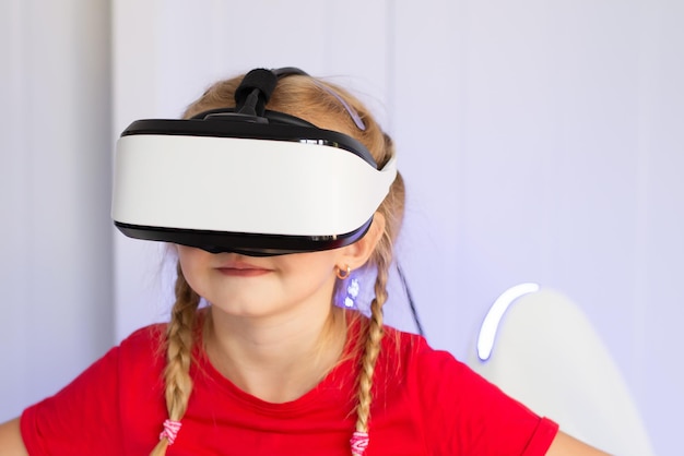 Un bambino con un visore per realtà virtuale che gioca a un gioco su una giostra o guarda un film in 3D