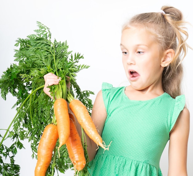 Un bambino con una carota vegetale