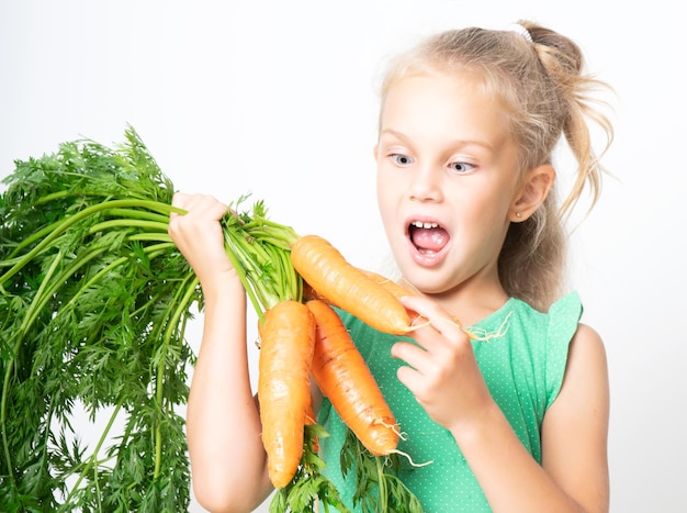 Un bambino con una carota vegetale