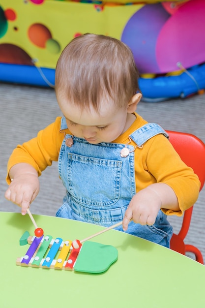 Un bambino di 2 anni suona lo xilofono nella stanza dei giochi