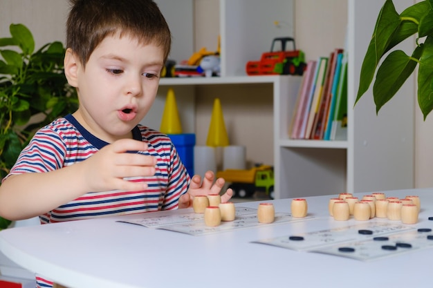 Un bambino di 4 anni gioca a loto, studia i numeri usando un gioco da tavolo.