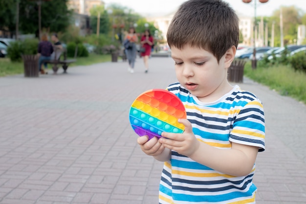 Un bambino di 4 anni gioca con Pop It nel parco cittadino.